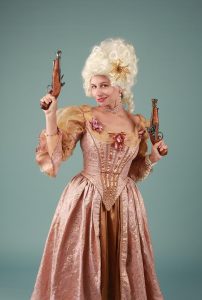 Woman in vintage dress with pistols, historical costume