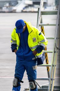 Airport worker in safety gear and kneepads