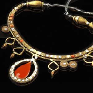 Ancient ornate necklace with red gemstone pendant