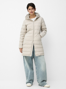 Woman wearing beige puffer coat and jeans.