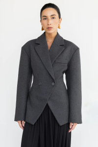 Woman in black blazer and skirt, gold earrings