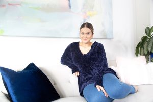 Woman in blue sweater sitting on couch