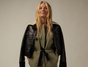 Person wearing leather jacket over green outfit.