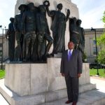 Man standing beside historical monument outdoors