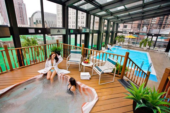 Indoor pool with jacuzzi and city view.